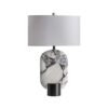 Lámpara de sobremesa Dilash de estilo art deco fabricado en mármol en color blanco con acabado veteado combinado con metal en color negro con acabado mate y poliéster en color blanco roto.